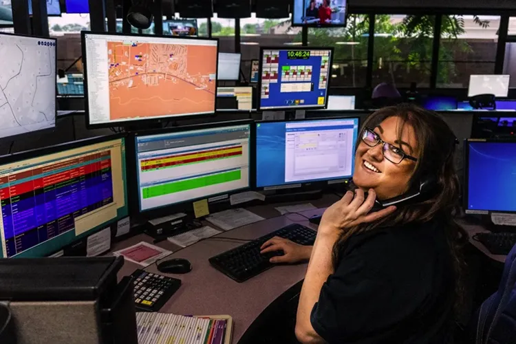 Prescott dispatcher in front of monitors on phone