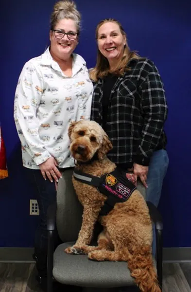 Service dog and two ladies smiling