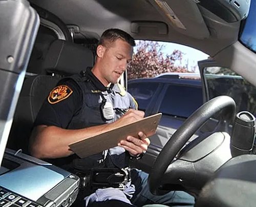 Prescott police officer with clipboard in vehicle.